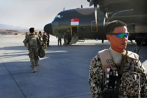 Members of the Singaporean armed forces prepare to board a C-130 Hercules aircraft June 22, 2013, at Multinational Base Tarin Kowt, Afghanistan. The plane was scheduled to fly Singaporean troops out of the country after Singapore ended its military mission in Afghanistan. The Singaporean military had deployed nearly 500 soldiers during its six-year mission in Afghanistan. (U.S. Army photo by Sgt. Jessi Ann McCormick/Released)