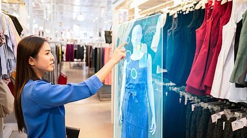 futuristic technology concept.happy girl try to use smart hologram display with virtual augmented reality in the shop or retail to choose select ,buy clothes and change a color of products.
