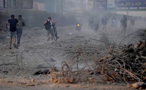 காசாவில் உள்ள மசூதி மீது இஸ்ரேல் ராணுவம் தாக்குதல் நடத்தியதை தொடர்ந்து போர் விமான சத்தம் கேட்டு ஓடும் மக்கள்