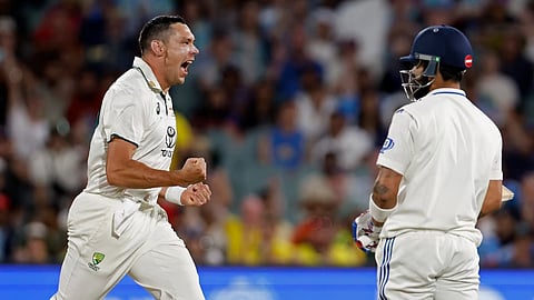 Virat Kohli (right) watches on as Scott Boland celebrates after dismissing the batter.