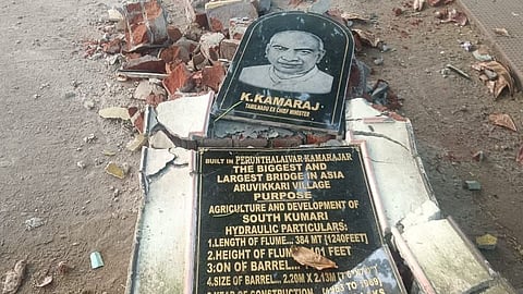 உடைந்து கிடைக்கும் காமராஜர் உருவம் பதித்த கல்வெட்டு