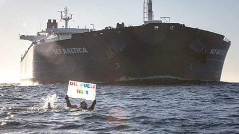 A Greenpeace protester attempts to block the movement of a Russian oil tanker.