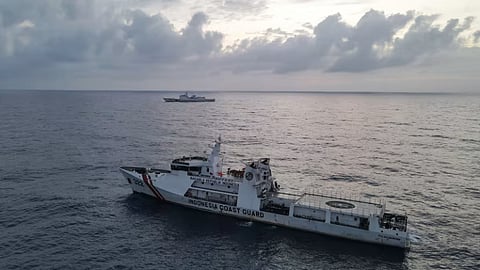 An Indonesian Sea and Coast Guard ship and a China coast guard vessel in the background, in the waters of Indonesia's North Natuna Sea in November 2021