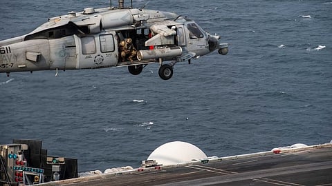 A US Navy MH-60S Seahawk helicopter from Helicopter Sea Combat Squadron Seven hovers above the flight deck of the aircraft carrier USS Dwight D. Eisenhower while in the US Fifth Fleet area of operations, December 24, 2023.
