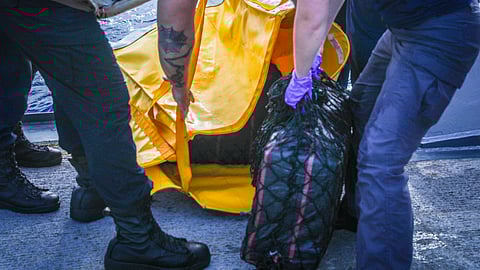 US Navy and US Coast Guard personnel handling bales containing the seized cocaine