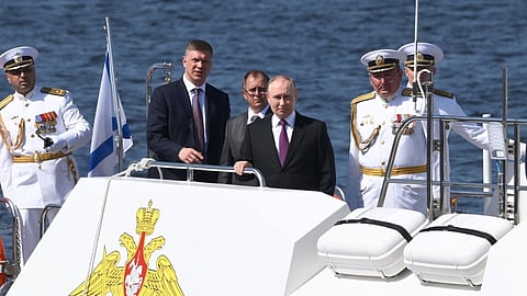 Vladimir Putin arrives at the St. Petersburg naval headquarters on Sunday by patrol speed boat