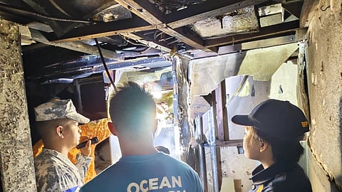Personnel of the Philippine Coast Guard and the Philippine Bureau of Fire Protection inspect the damage caused by the fire that had ignited on the Ro-Pax ferry Monreal off Quezon province, August 27, 2025.