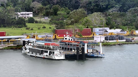 A train belonging to the Panama Canal Railway passes two ferries used to carry passengers and cargo across the canal at Gamboa, Panama.