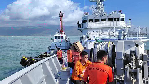 Philippine Coast Guard personnel aboard the multi-role response vessel (MRRV) BRP Teresa Magbanua transfer relief aid to a waiting tug off Catanduanes province in the Philippines, November 11, 2025. The MRRV was deployed to Catanduanes to support disaster response efforts in areas that had been affected by Typhoon Fung-Wong.