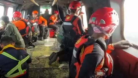Personnel from Indonesia's Basarnas search and rescue agency conduct an aerial search of the waters off Papua province in an attempt to locate 17 people who have gone missing after a speedboat capsized in the area on December 24, 2025.