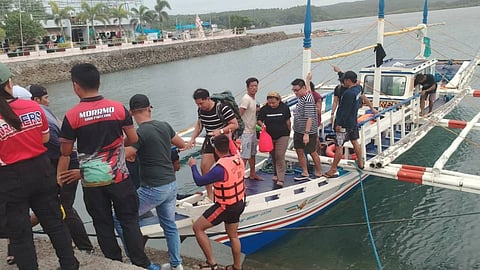 Rescued passengers of the half-submerged recreational boat Harlyn 1 after they were brought ashore by another vessel in Masbate, Philippines, January 3, 2026