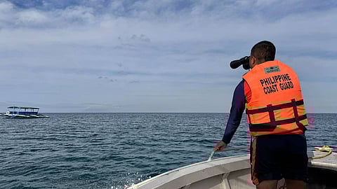 A Philippine Coast Guard sailor scours the waters off Occidental Mindoro province for any sign of the fishing boat MJ2 or its four crewmembers, February 11, 2026. The vessel was initially reported missing two days prior after it failed to return from a fishing trip.