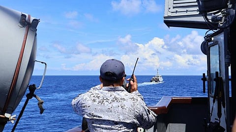A Philippine Navy sailor aboard the patrol ship BRP Artemio Ricarte observe the Indonesian Navy patrol boat KRI Selar off in the distance while both vessels are patrolling the Philippine-Indonesian maritime boundary, May 25, 2026.