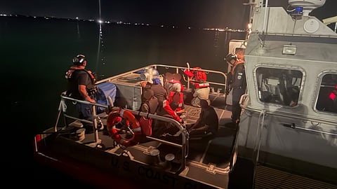 A US Coast Guard Station San Juan boat crew oversees a group of eight stowaway aliens apprehended moments earlier aboard the barge Charlotte Bridge as it was being towed into San Juan Harbor, Puerto Rico, May 22, 2026. The apprehended stowaways were transferred to the US Customs and Border Protection San Juan Field Office personnel for further processing.