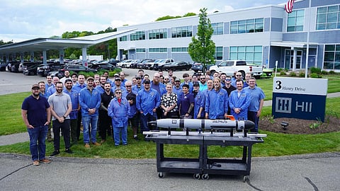 HII personnel with the first unit of the company's new unmanned underwater vehicle series in the foreground