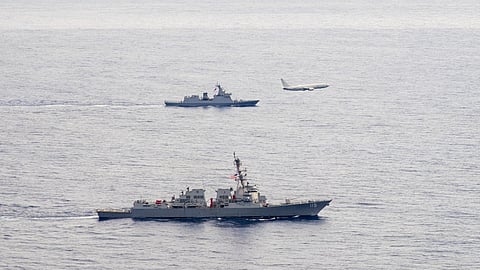 A US Navy P-8A Poseidon patrol aircraft assigned to Patrol Squadron 45 executes a low-altitude flyover as the US Navy Arleigh Burke-class guided-missile destroyer USS Rafael Peralta (nearest to camera) steams in formation with the Philippine Navy frigate BRP Jose Rizal in the South China Sea, December 10, 2025.