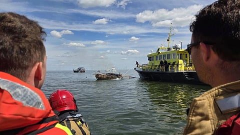Royal Netherlands Sea Rescue Institution personnel observe the burned-out yacht, August 2, 2026.