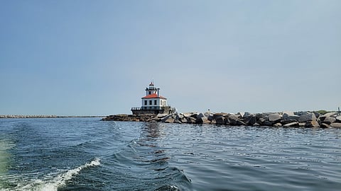The Oswego Harbor West Pierhead Lighthouse stands as an active aid to navigation at the end of a breakwater located off the coast of Oswego, New York