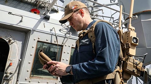 Master-at-Arms 1st Class Everest Austerman operates a Drone Restricted Access Using Known Electromagnetic Warfare (DRAKE) anti-drone system during a simulated straits transit aboard the Arleigh Burke-class guided-missile destroyer USS Porter.