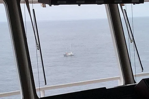 The disabled and adrift sailing vessel Miss Lilly is seen through the window of the bridge of President Eisenhower, a 300-metre containership, approximately 500 nautical miles south southwest of Dutch Harbor, Alaska, June 4, 2020. (Photo: US Coast Guard)