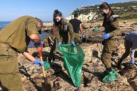 Soldiers of the Israel Defense Force assist in cleaning up a large quantity of oil that had washed ashore on Israel's Mediterranean coast in February 2021. (Photo: Israel Defense Forces)