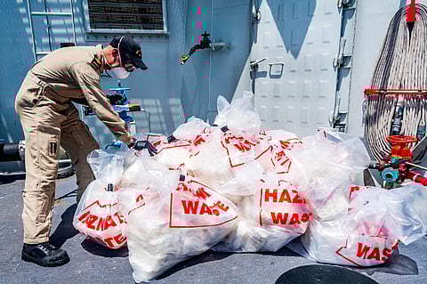 Master Sailor John Lesson, a Weapons Engineering Technician aboard HMCS Calgary, inspects contraband seized during a counter-smuggling operation on April 24, 2021, in the Arabian Sea (Photo: Royal Canadian Navy/Corporal Lynette Ai Dang)
