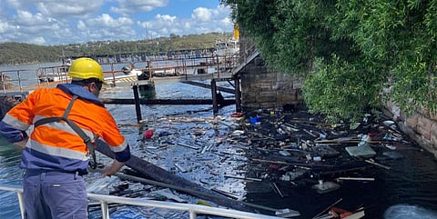 An NSW Maritime employee surveys the debris caused by the sinking of the former Manly ferry Baragoola, which is seen here partially hidden in the background. The 99-year-old vessel sank at its moorings in Sydney Harbour on January 1, 2022. (Photo: NSW Maritime)