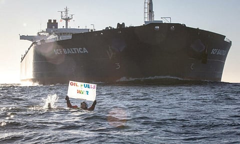 A protester attempts to block the movement of a Russian oil tanker
