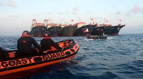 Philippine Coast Guard personnel on board rubber boats face Chinese fishing vessels in the West Philippine Sea on April 14, 2021. (Photo: Philippine Coast Guard)