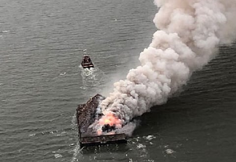 The towing vessel Daisy Mae pulling the CMT Y Not 6 barge with scrap metal cargo on fire, May 23, 2022.
(Photo: US Coast Guard)