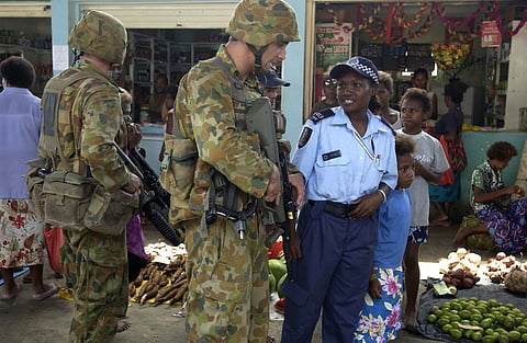 Private Shaun Dwyer from the 1st Battalion The Royal Australian Regiment based in Townsville conducts a patrol with a Royal Solomon Islands Police Officer in Honiara Markets in the Solomon Islands.  3f51ec9d49bc461803b454a4875d5aa8