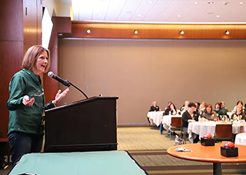 Maureen Jorgensen speaks to colleagues during Peoples State Bank’s annual President’s Day retreat. This particular retreat was held at Lambeau Field, thus the green and gold attire.