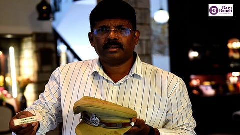 Prateep V Philip with his name badge and cap