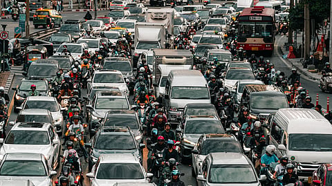 Photo of Bangkok traffic, capturing cars, motorcycles, and people on a bustling city street