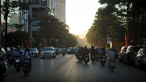 Photo of bustling street traffic in Hanoi, Vietnam at sunset