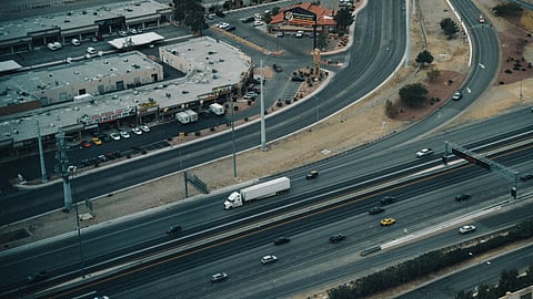 Photo of aerial shot of a highway in Las Vegas showing traffic and nearby commercial area