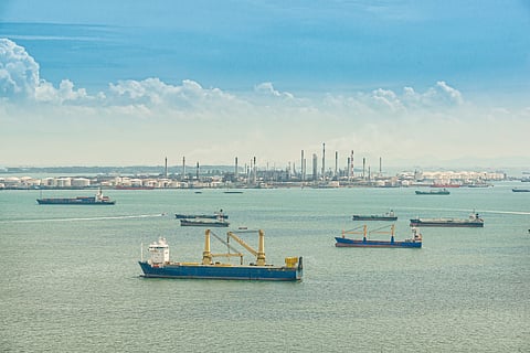 Photo of vessels in waters off refinery and storage tanks in Singapore