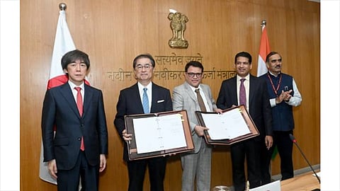 Company and government representatives stand at a New Delhi ceremony while two participants display the signed green ammonia and green methanol offtake agreements.