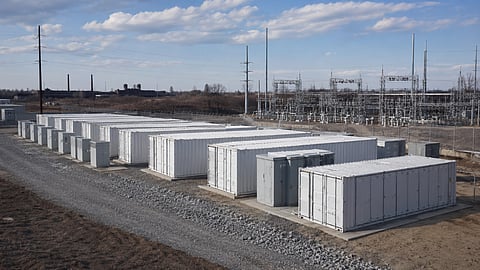 An editorial visual depicts containerised BESS units on brownfield land in connection with Nofar USA's approximately 400 MWh project, which has secured site approval and grid interconnection.
