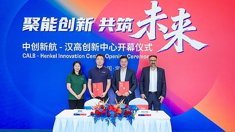 Four CALB and Henkel representatives stand before the innovation center opening ceremony backdrop.