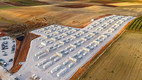 Aerial view of white battery containers in rows among farm fields in Thessaly, Greece.