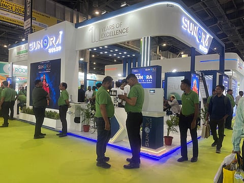 Sunora Solar stand at REI Expo 2026 with lit SUNORA signs, screens showing its panels.