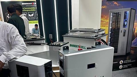 Bharat Cell lithium battery packs on a round platform in front of a banner.