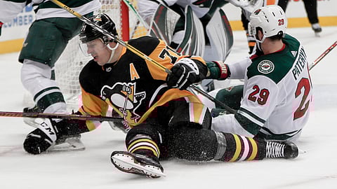 Pittsburgh Penguins’ Evgeni Malkin (71) and Minnesota Wild’s Greg Pateryn (29) hit the ice during the second period of an NHL hockey game Thursday, Dec. 20, 2018, in Pittsburgh. (AP Photo/Keith Srakocic)