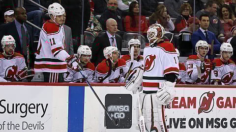 New Jersey Devils goaltender Keith Kinkaid (1) skates past the Devils’ Brian Boyle (11) and head coach John Hynes, center (in suit), after being replaced during the second period of an NHL hockey game Sunday, Dec. 23, 2018, in Newark, N.J. (AP Photo/Adam Hunger)