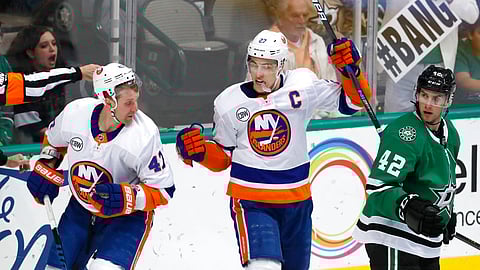 New York Islanders left wing Anders Lee (27) and right wing Leo Komarov (47) celebrate a goal as Dallas Stars defenseman Taylor Fedun (42) looks on during the second period of an NHL hockey game in Dallas, Sunday, Dec. 23, 2018. (AP Photo/LM Otero)