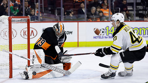 Philadelphia Flyers’ Carter Hart, left, blocks a shot by Boston Bruins’ Danton Heinen during the first period of an NHL hockey game, Wednesday, Jan. 16, 2019, in Philadelphia. (AP Photo/Matt Slocum)