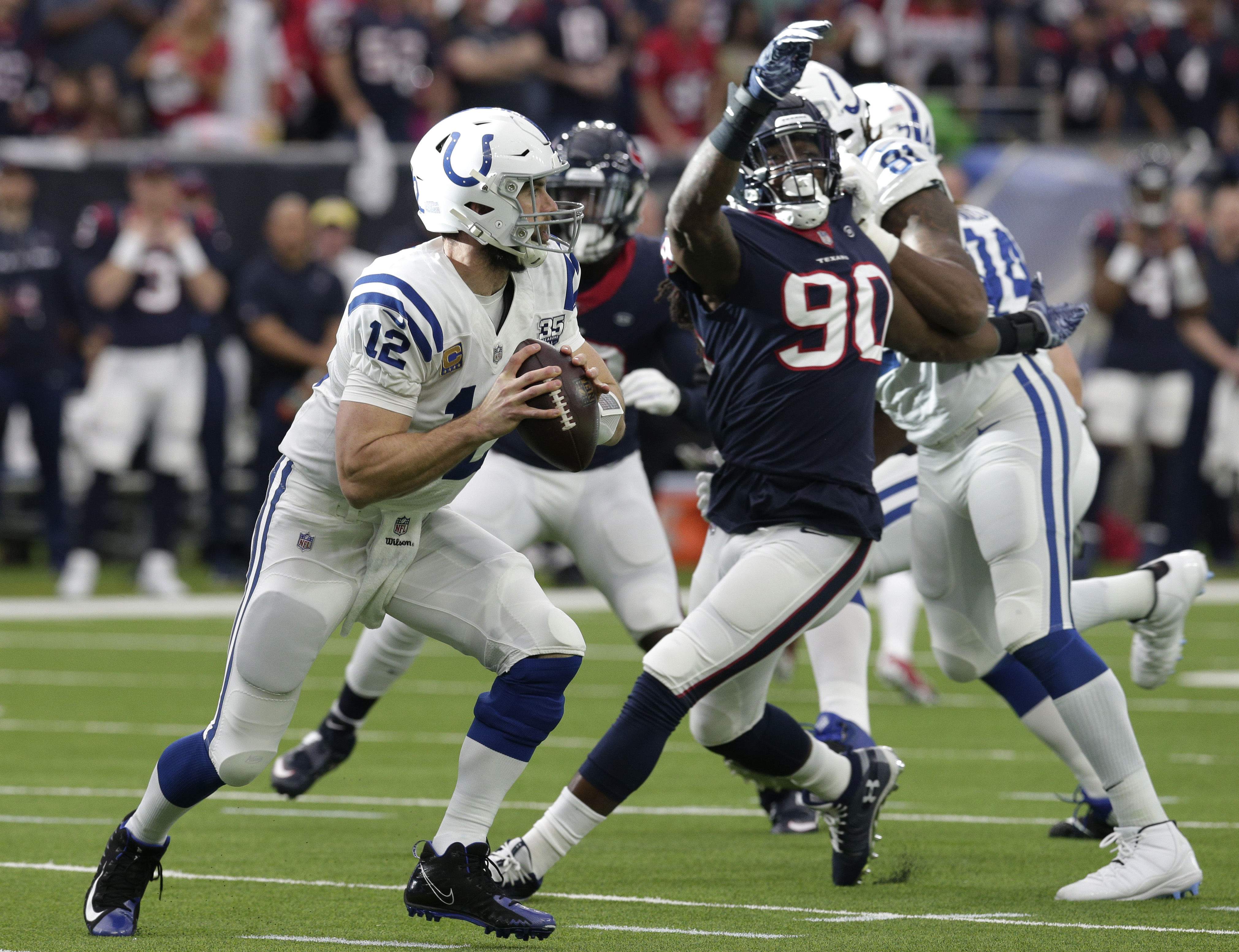 Indianapolis Colts quarterback Andrew Luck (12) is pressured by Houston Texans outside linebacker Jadeveon Clowney (90) during the first half of an NFL wild card playoff football game, Saturday, Jan. 5, 2019, in Houston. (AP Photo/Michael Wyke)