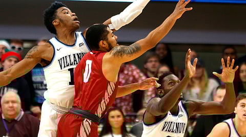 Villanova forward Saddiq Bey (15) and forward Dhamir Cosby-Roundtree (21) reach for a rebound with Saint Joseph’s guard Lamarr Kimble (0) during the first half of an NCAA college basketball game, Saturday, Dec. 8, 2018, in Villanova, Pa. (AP Photo/Laurence Kesterson)