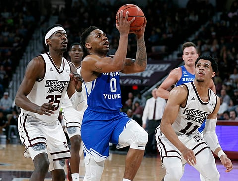 Brigham Young guard Jahshire Hardnett (0) leaps past Mississippi State forward Aric Holman (35) and guard Quinndary Weatherspoon (11) during the second half of an NCAA college basketball game in Starkville, Miss., Saturday, Dec. 29, 2018. Mississippi State won 103-81. (AP Photo/Rogelio V. Solis)
